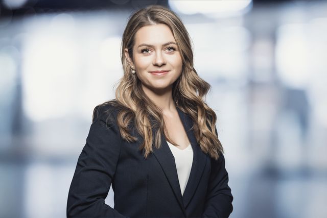 Bewerbungsfoto einer jungen Frau im schwarzen Blazer