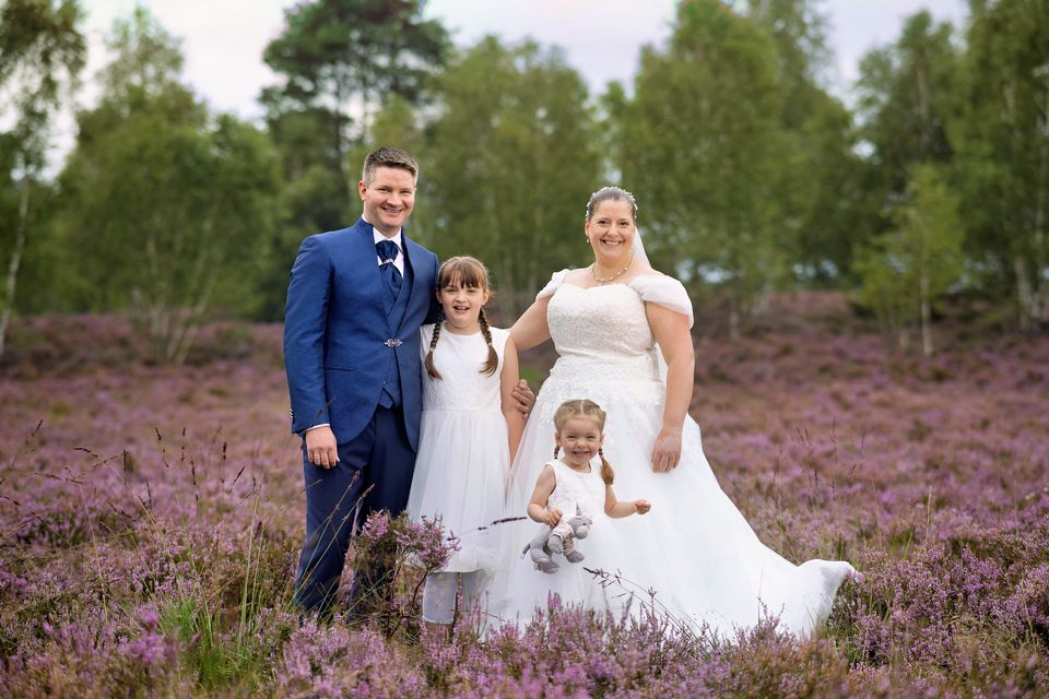 Brautpaar mit Kindern in der blühenden Heide