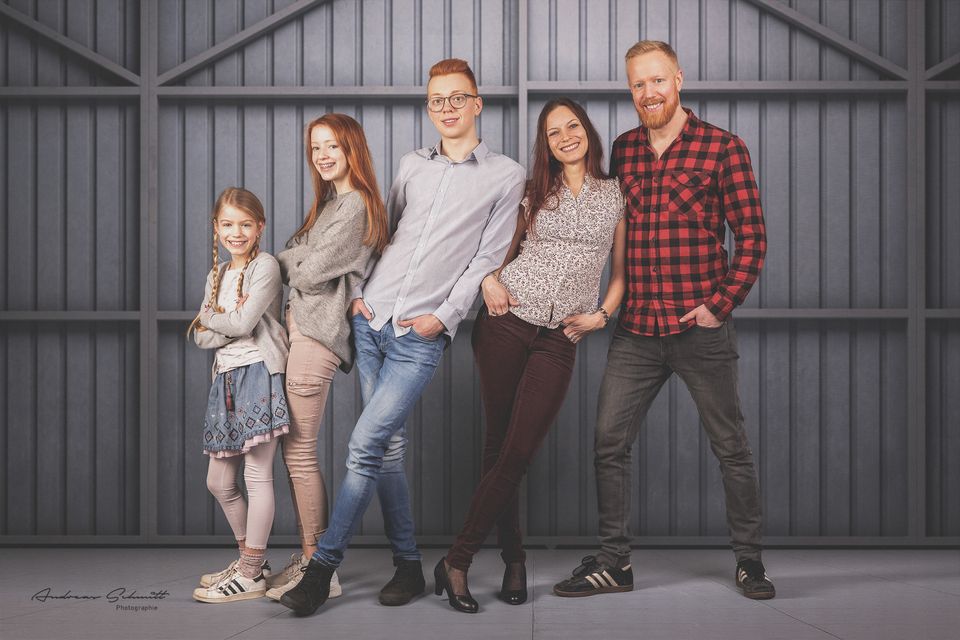 Fünfköpfige Familie im Studio vor einem Holztor