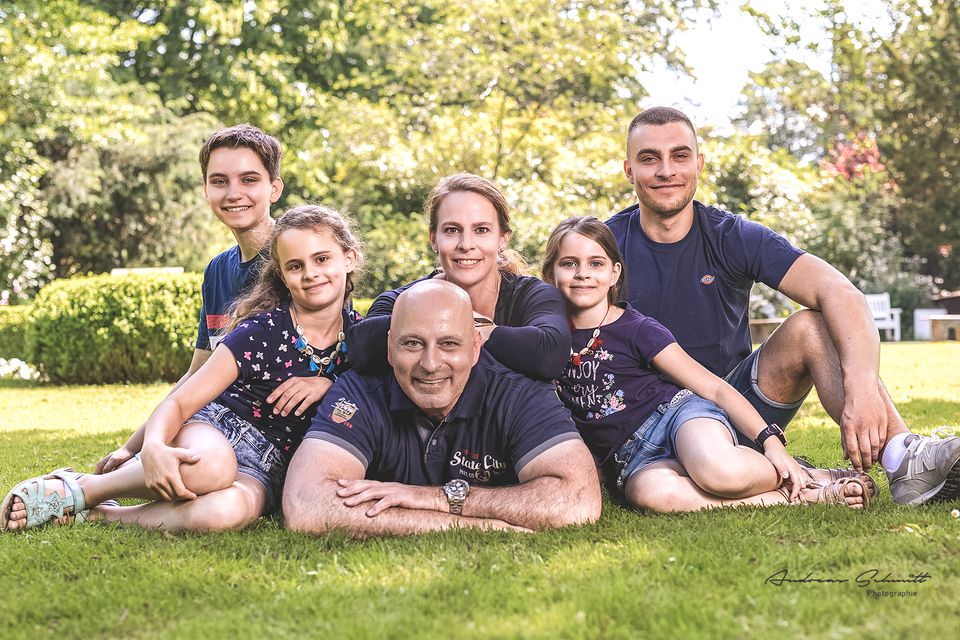 Große Familie liegt lachend auf einer Wiese