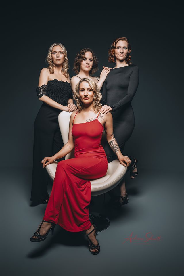 Vier Frauen in Abendkleidern